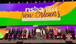 NSBA's Board of Directors wearing capes on stage at NSBA's Annual Conference