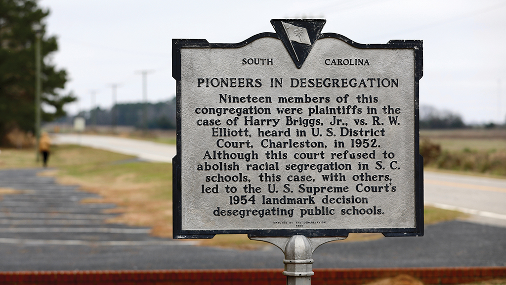 A historical marker that reads "Pioneers in Desegregation" outside Liberty Hill AME Church