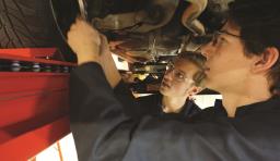 Two students work on a car