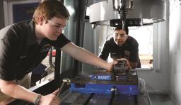 Two students work on a machine