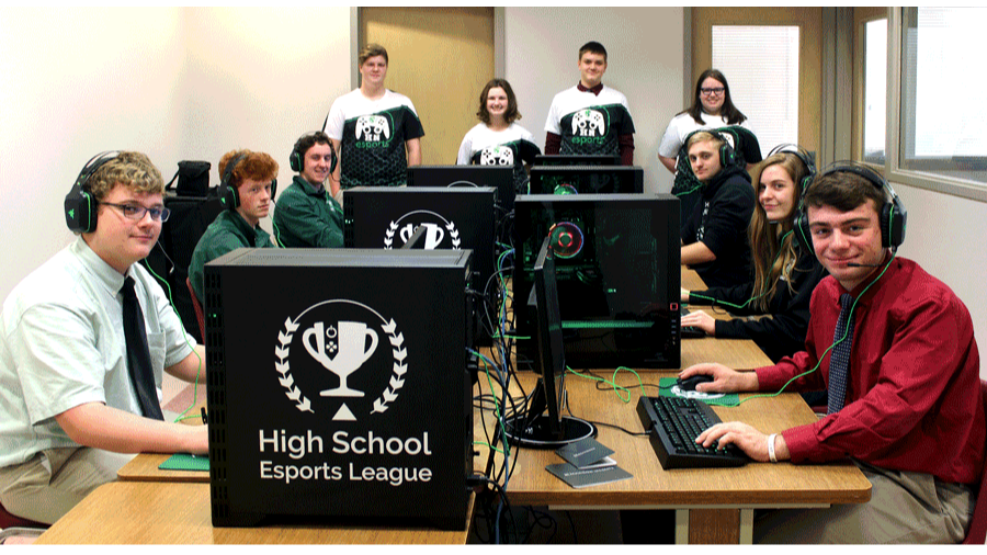 students pose for a picture in front of their computers 