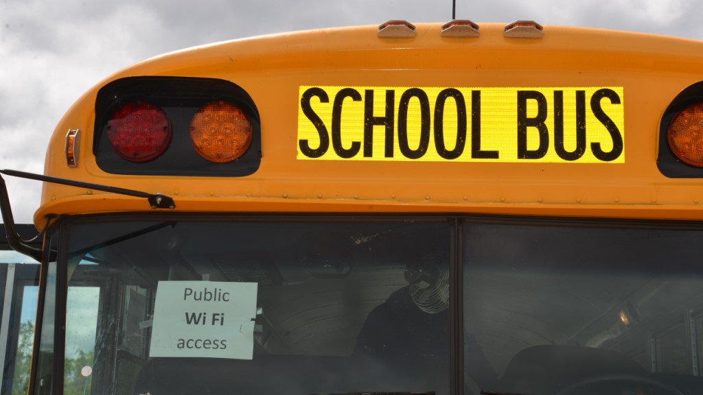 a school bus with a sign declaring "public wifi access"