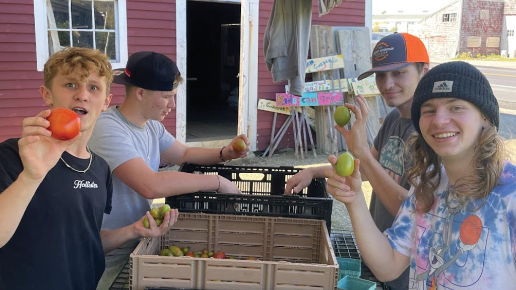 High school students show off the fruit they have recently harvested. 