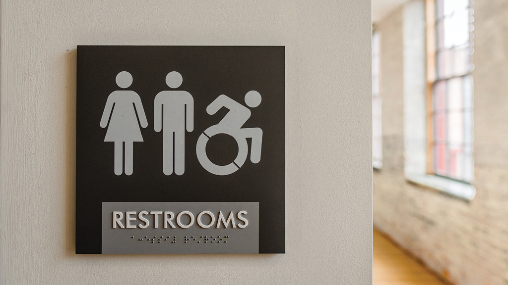 A bathroom plaque shows the icon for male, female, and disability access.